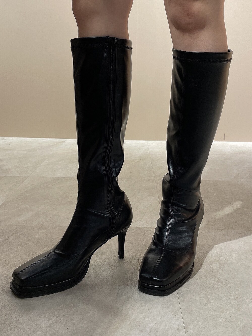 ブラック系のニット/セーター、グレー系のチェスターコート、ブラック系のブーツを着用したレディースの秋コーディネートの10枚目の写真