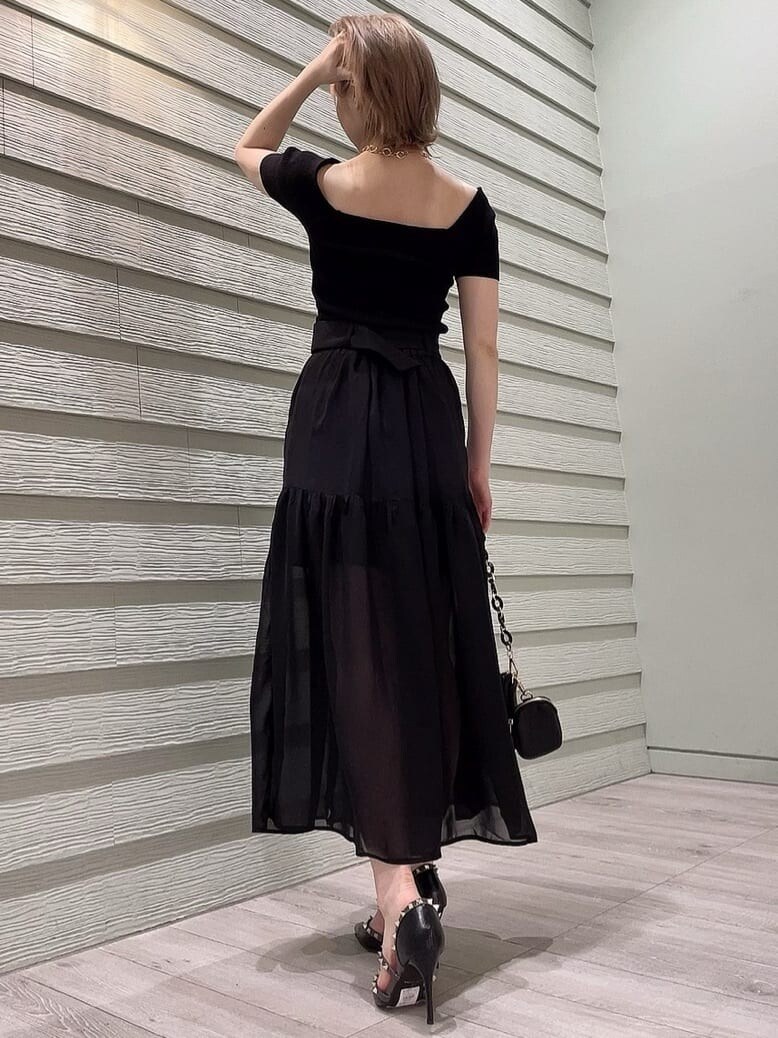 ブラック系のパンプス、ブラック系のニット/セーター、ブラック系のスカートを着用したレディースの春コーディネートの4枚目の写真