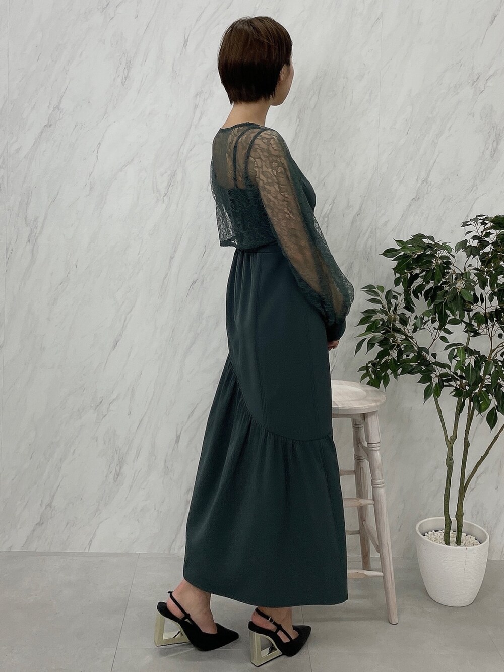 ブラック系のサンダル、グリーン系のワンピースを着用したレディースの秋コーディネートの4枚目の写真