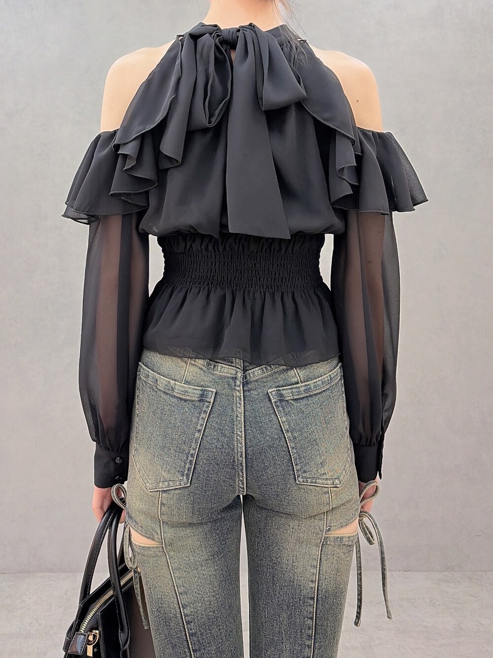ブラック系のシャツ/ブラウス、ブルー系のデニムパンツ、ブラック系のハンドバッグを着用したレディースの秋コーディネートの6枚目の写真