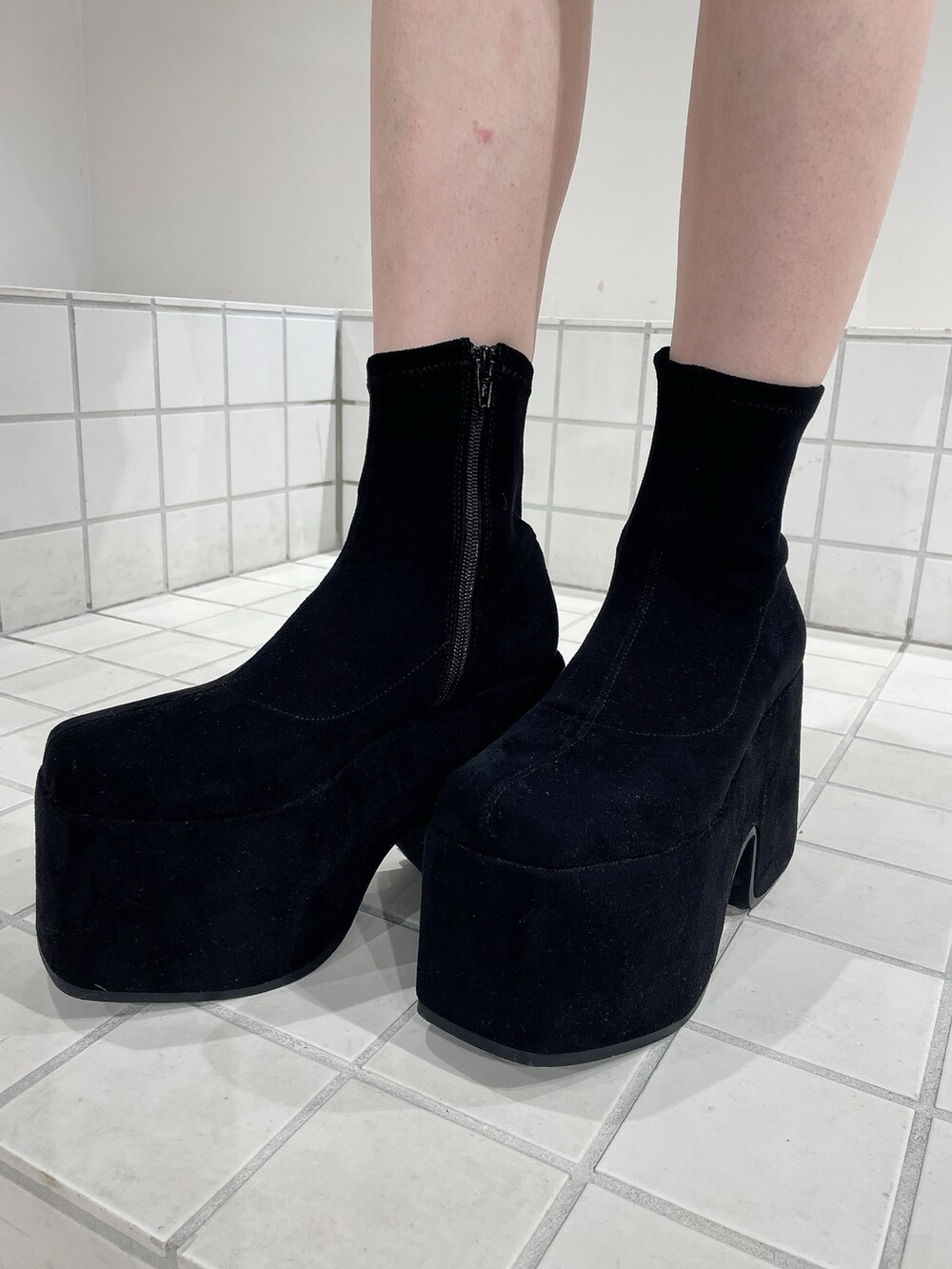 レッド系のニット/セーター、ブルー系のデニムパンツ、ブラック系のブーツを着用したレディースの秋コーディネートの9枚目の写真