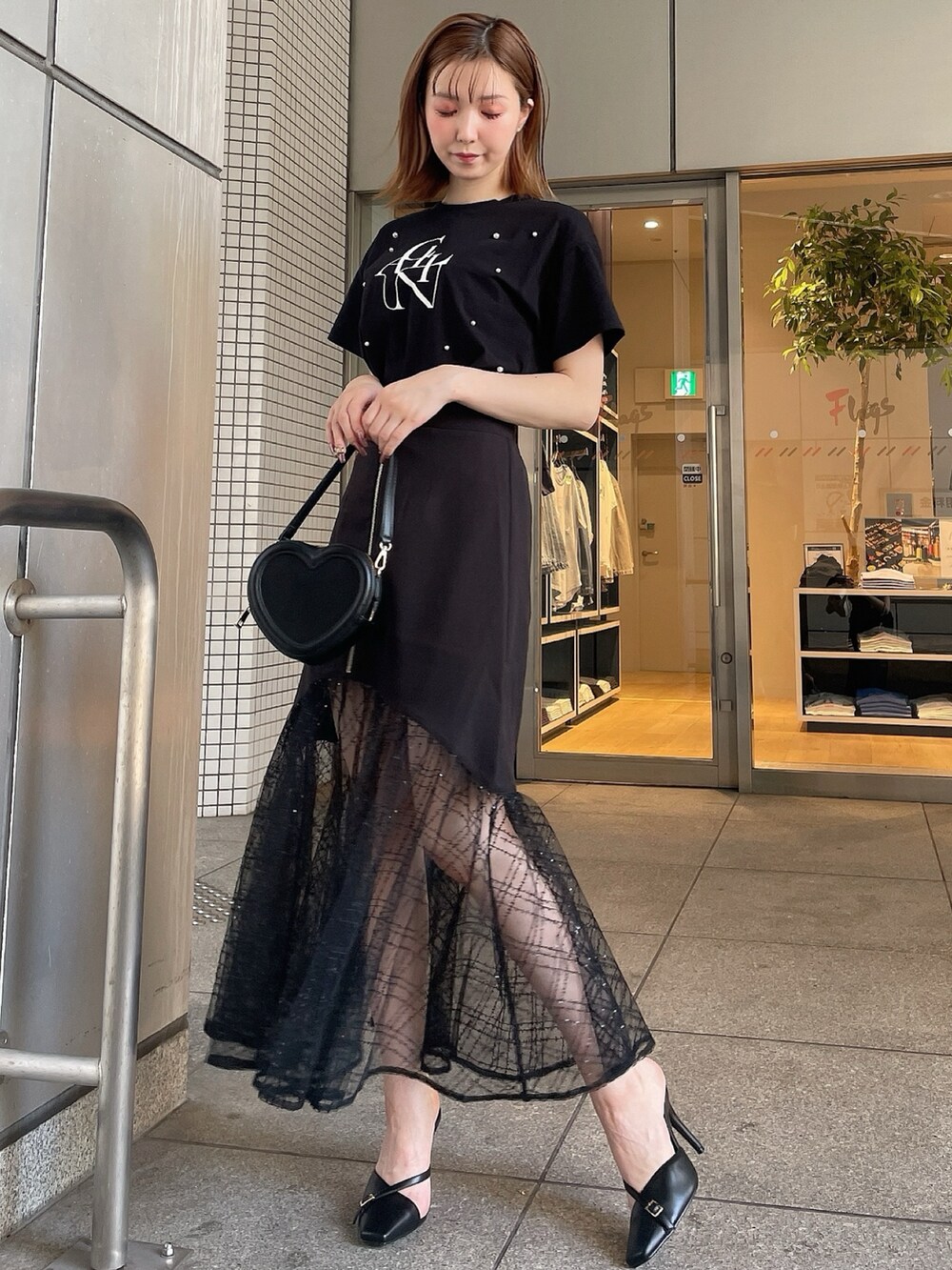 ブラック系のスリッポン、ブラック系のTシャツ/カットソー、ブラック系のスカートを着用したレディースの夏コーディネートの3枚目の写真