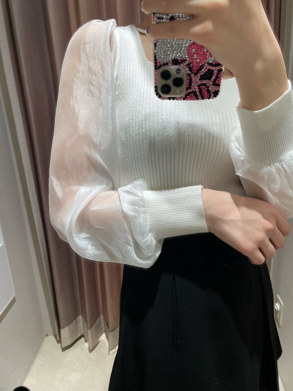 ホワイト系のニット/セーター、ブラック系のスカート、ブラック系のブーツを着用したレディースの冬コーディネートの7枚目の写真