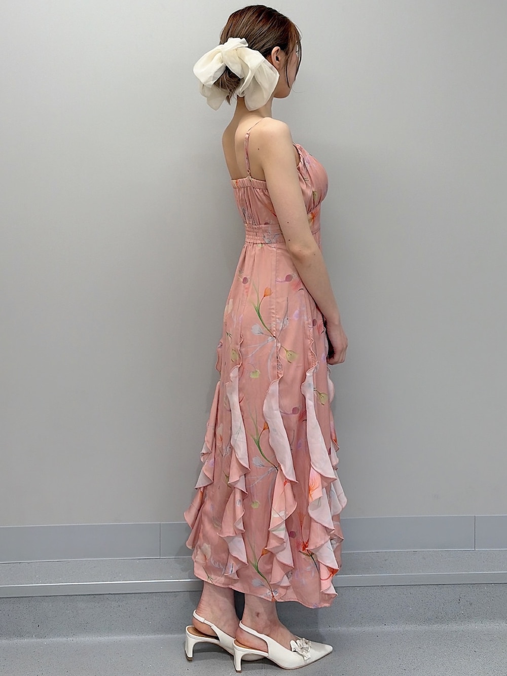 ホワイト系のパンプス、オレンジ系のワンピース、ホワイト系のバレッタ/ヘアクリップを着用したレディースの冬コーディネートの7枚目の写真