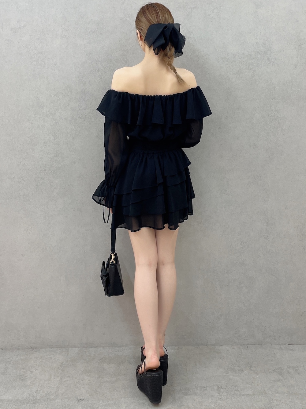 ブラック系のワンピース、ブラック系のハンドバッグ、ブラック系のサンダルを着用したレディースの春コーディネートの4枚目の写真