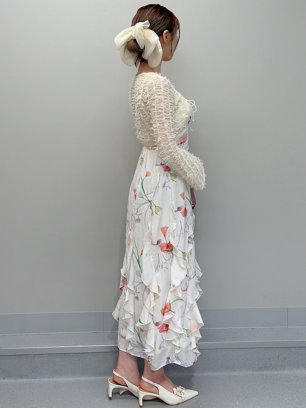 ホワイト系のワンピース、ピンク系のショルダーバッグ、ホワイト系のパンプスを着用したレディースの冬コーディネートの2枚目の写真