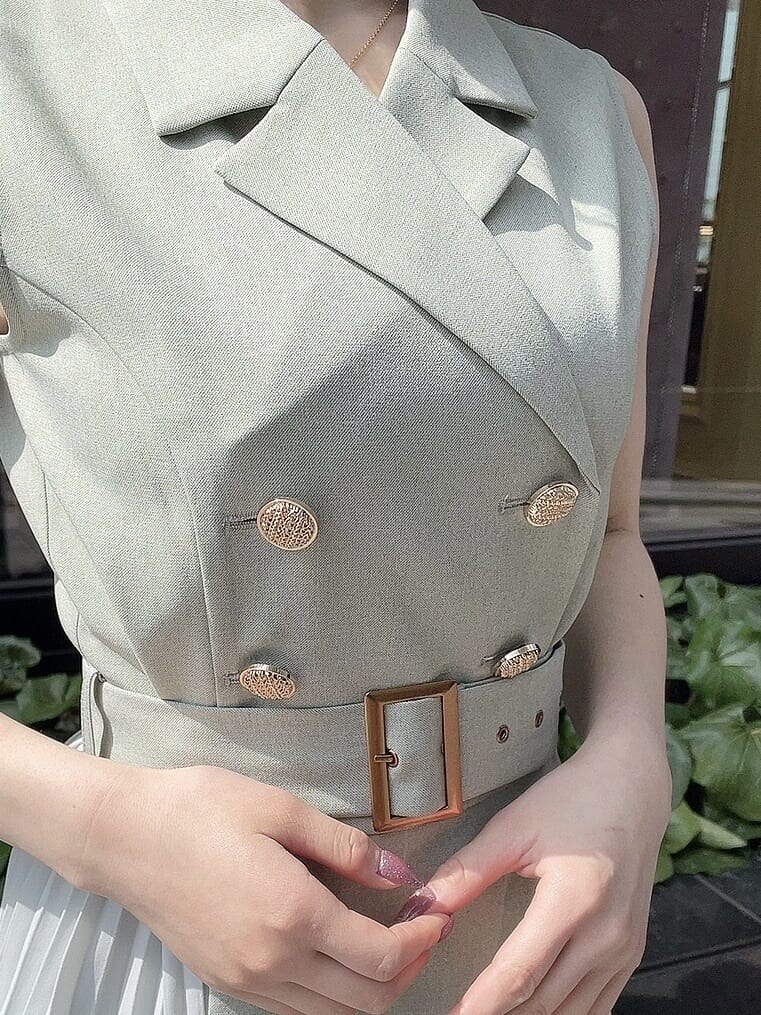 ホワイト系のパンプス、グリーン系のワンピース、ゴールド系のネックレスを着用したレディースの春コーディネートの5枚目の写真