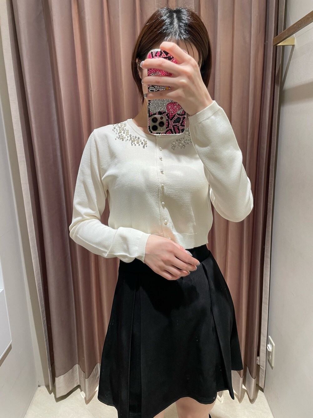 ホワイト系のカーディガン/ボレロ、ブラック系のスカート、ブラック系のブーツを着用したレディースの冬コーディネートの4枚目の写真