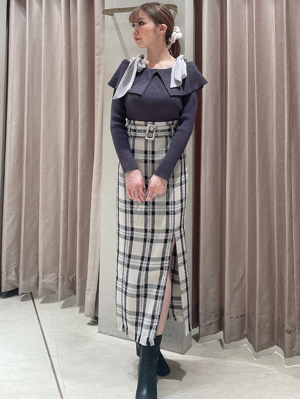 ブラック系のダウンジャケット/コート、グレー系のニット/セーター、ホワイト系のスカートを着用したレディースの秋コーディネートの6枚目の写真