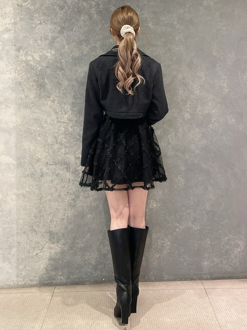 グレー系のその他アウター、ブラック系のワンピース、ブラック系のブーツを着用したレディースの秋コーディネートの2枚目の写真