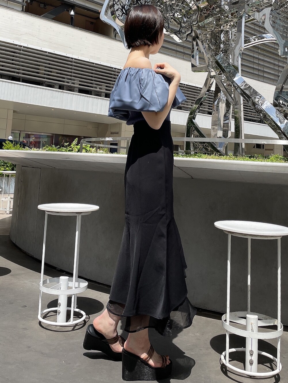 ブラック系のサンダル、ブルー系のニット/セーター、ブラック系のスカートを着用したレディースの春コーディネートの3枚目の写真