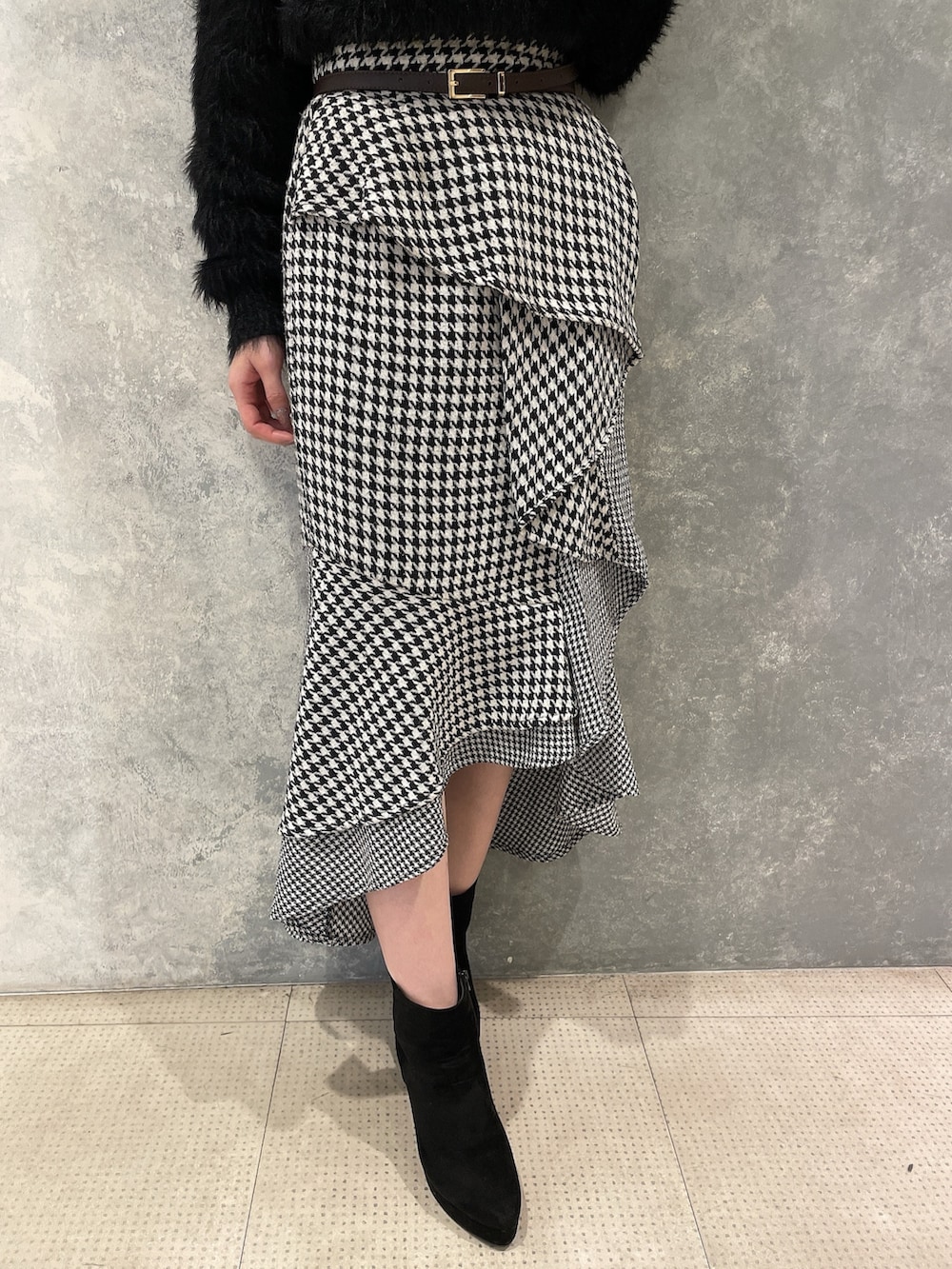 その他のスカート、ブラック系のカーディガン/ボレロ、ブラック系のブーツを着用したレディースの秋コーディネートの9枚目の写真