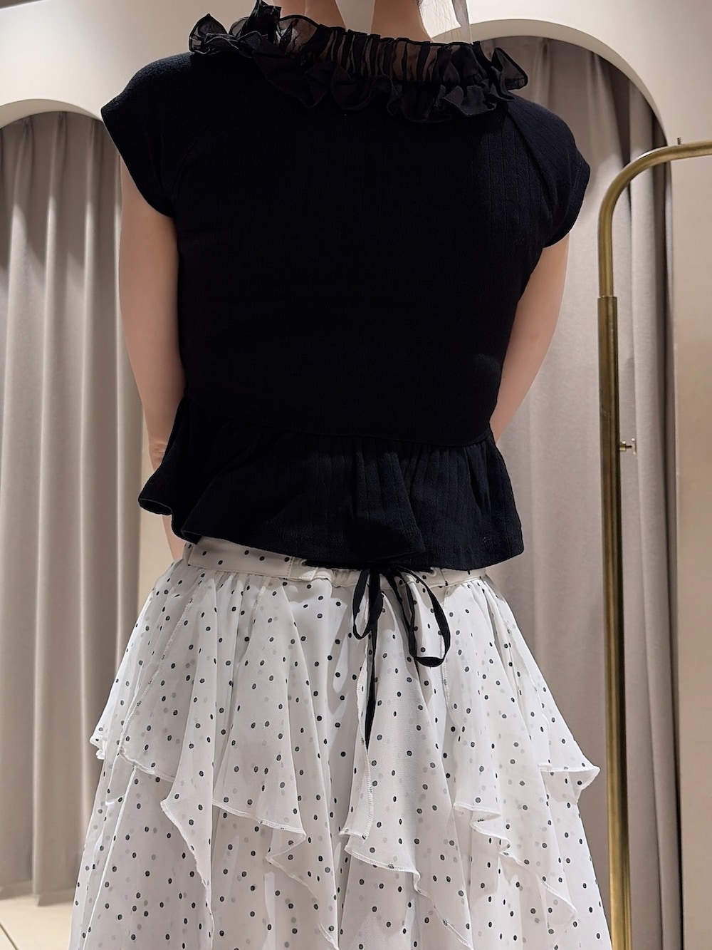 ブラック系のTシャツ/カットソー、ホワイト系のスカート、ブラック系のパンプスを着用したレディースの夏コーディネートの6枚目の写真