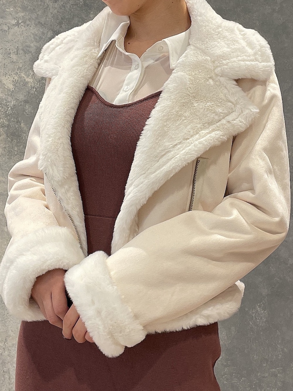 ブラック系のブーツ、ホワイト系のブルゾン、ブラウン系のワンピースを着用したレディースの秋コーディネートの8枚目の写真