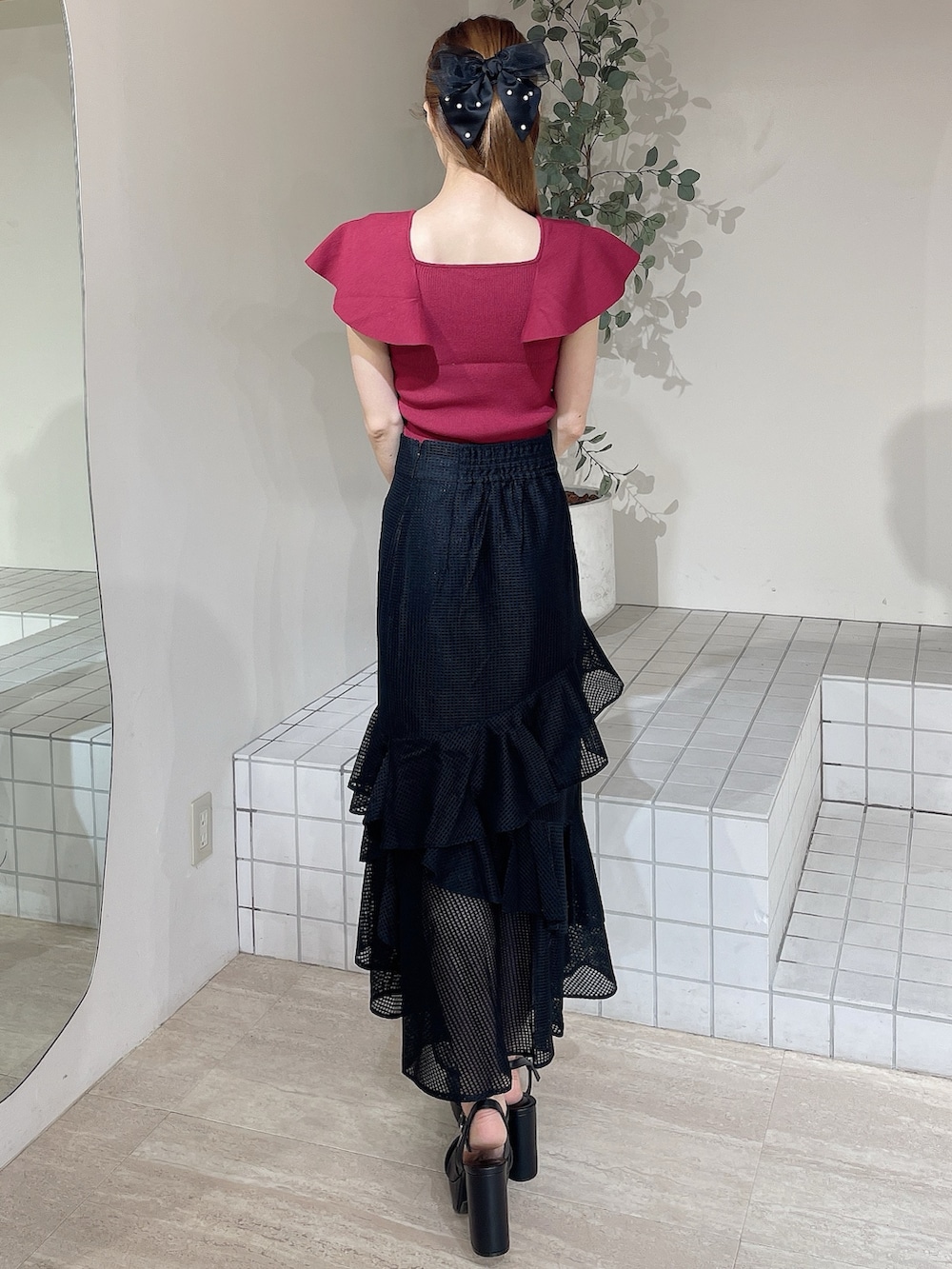 ブラック系のサンダル、レッド系のニット/セーター、ブラック系のスカートを着用したレディースの夏コーディネートの3枚目の写真