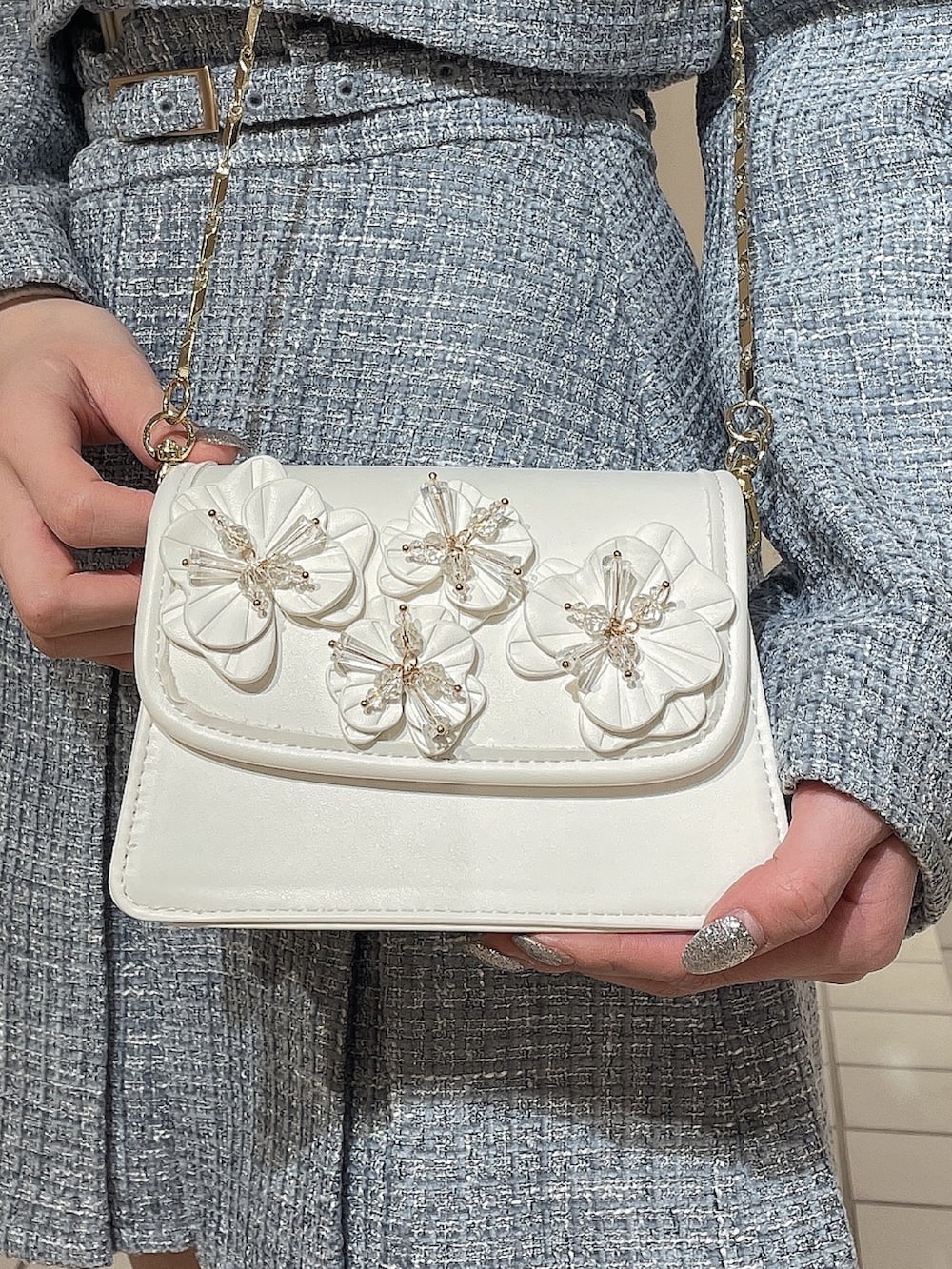 ブルー系のワンピース、ホワイト系のショルダーバッグ、ホワイト系のブーツを着用したレディースの冬コーディネートの7枚目の写真