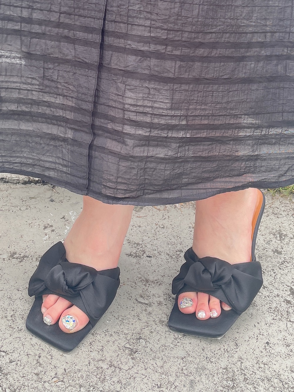 ブラック系のワンピース、ブラック系のサンダルを着用したレディースの夏コーディネートの7枚目の写真