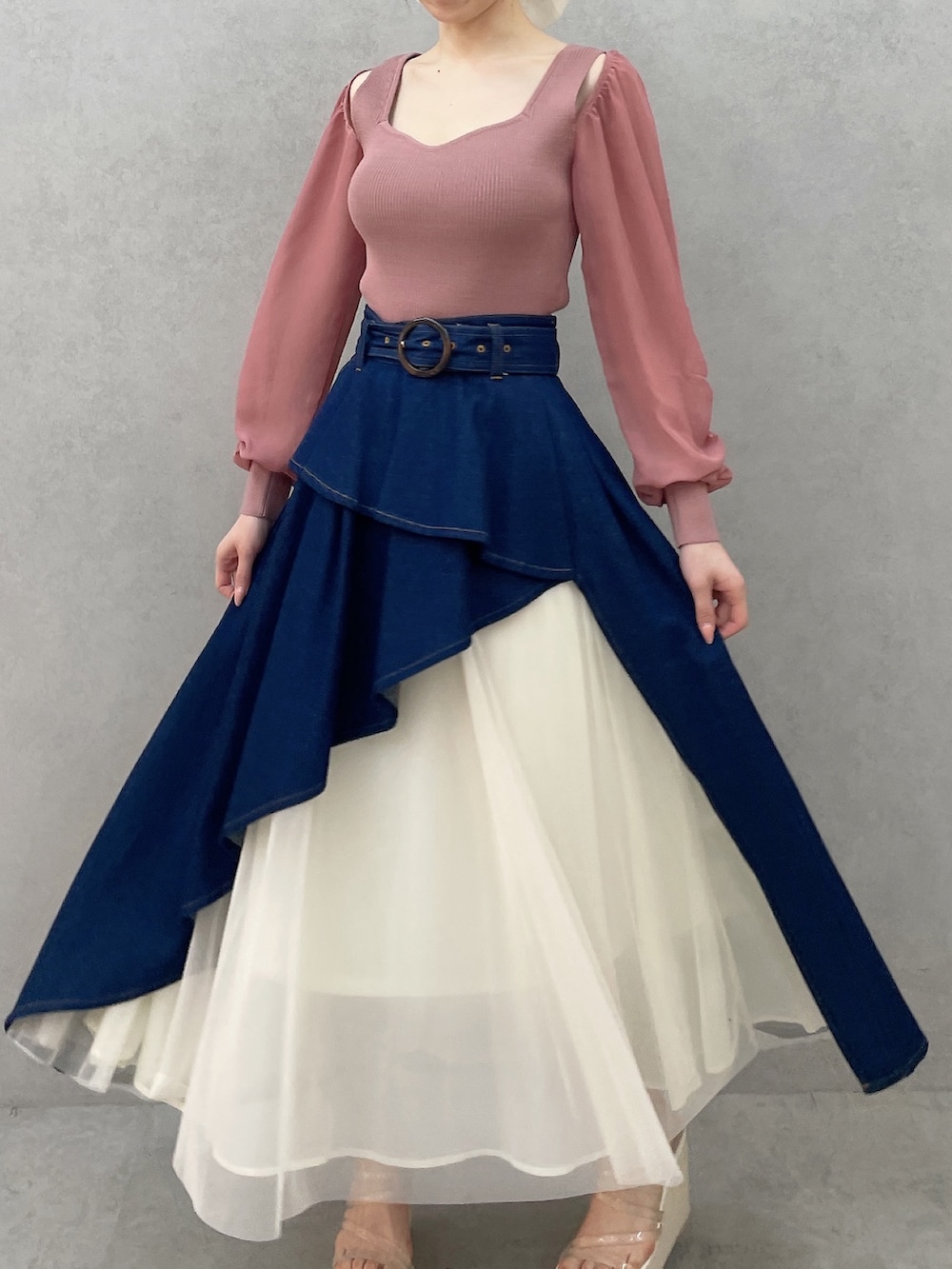 ピンク系のニット/セーター、ブルー系のスカート、ホワイト系のサンダルを着用したレディースの春コーディネートの2枚目の写真