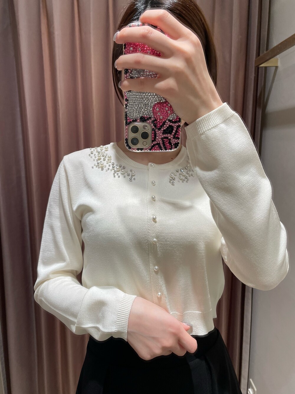 ホワイト系のカーディガン/ボレロ、ブラック系のスカート、ブラック系のブーツを着用したレディースの冬コーディネートの5枚目の写真