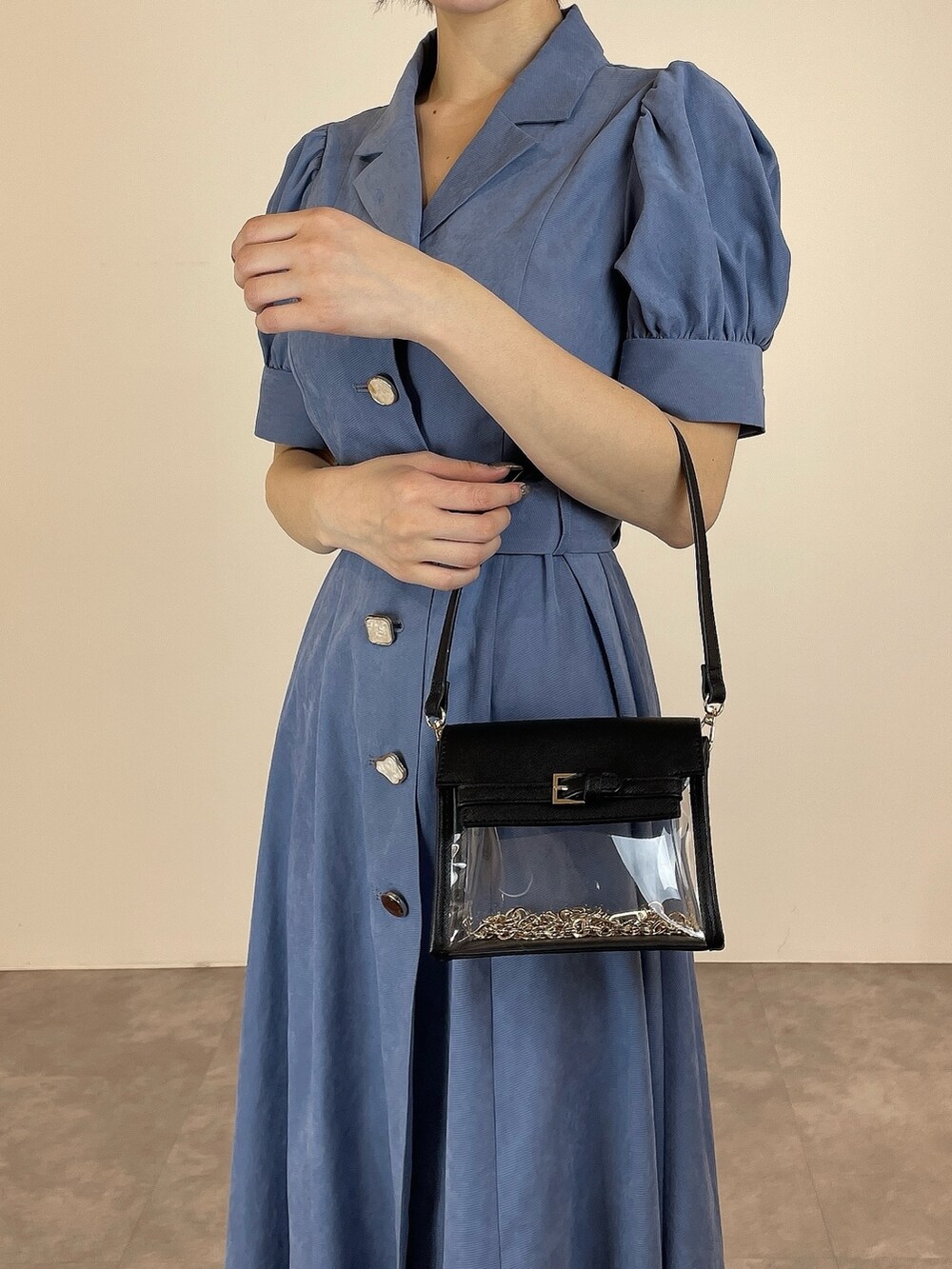 ブルー系のワンピース、ブラック系のパンプス、ブラック系のハンドバッグを着用したレディースの冬コーディネートの8枚目の写真