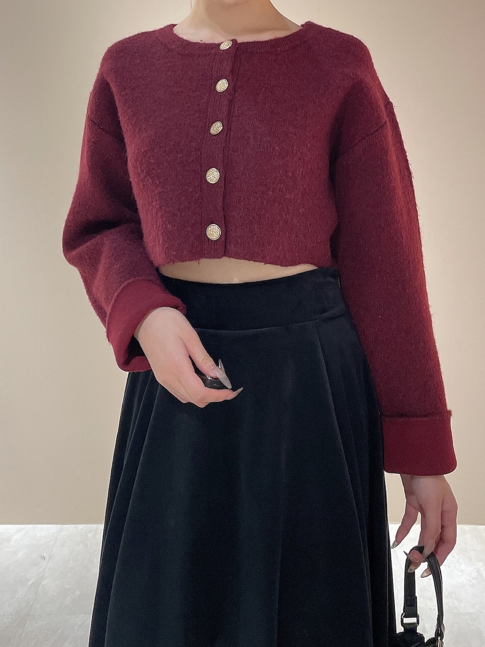 ブラック系のブーツ、レッド系のカーディガン/ボレロ、ブラック系のハンドバッグを着用したレディースの秋コーディネートの6枚目の写真