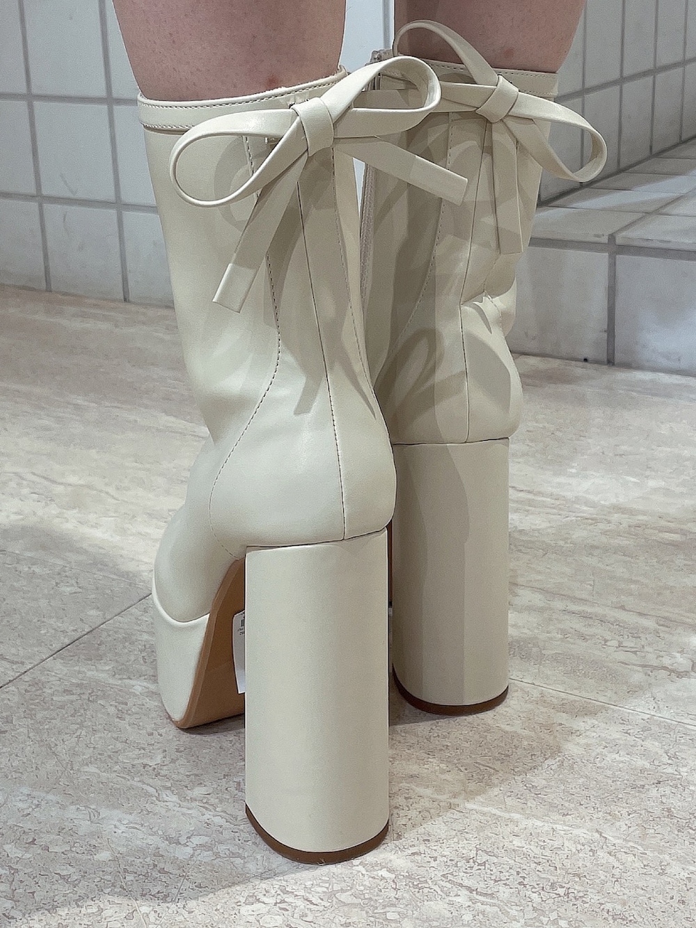 ブラック系のニット/セーター、ブルー系のデニムパンツ、ホワイト系のブーツを着用したレディースの冬コーディネートの7枚目の写真