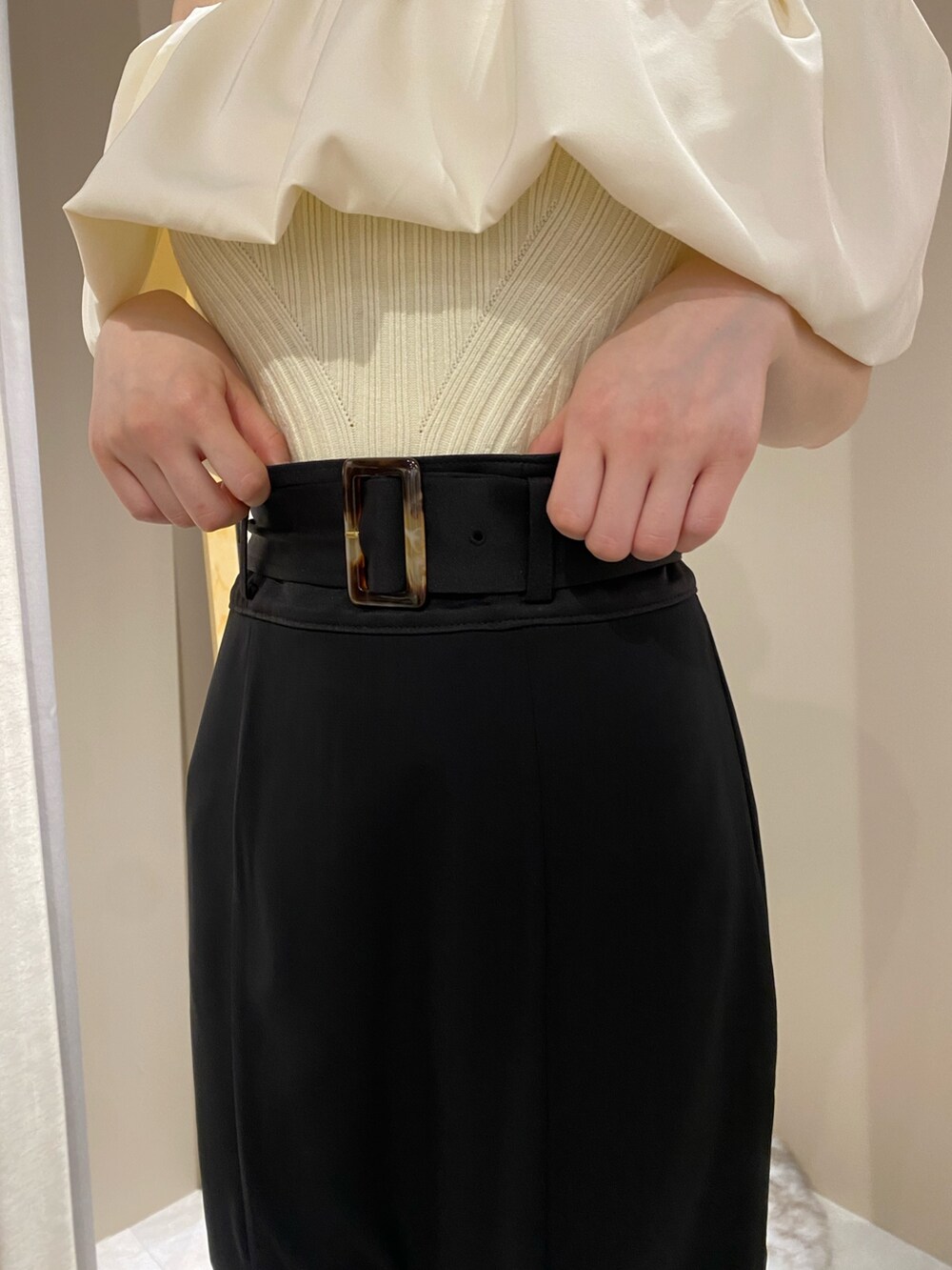 ホワイト系のパンプス、ホワイト系のニット/セーター、ブラック系のスカートを着用したレディースの春コーディネートの7枚目の写真