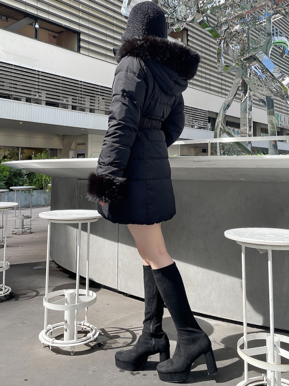 ブラック系のダウンジャケット/コート、ブラック系のブーツ、ブラック系のハットを着用したレディースの秋コーディネートの2枚目の写真