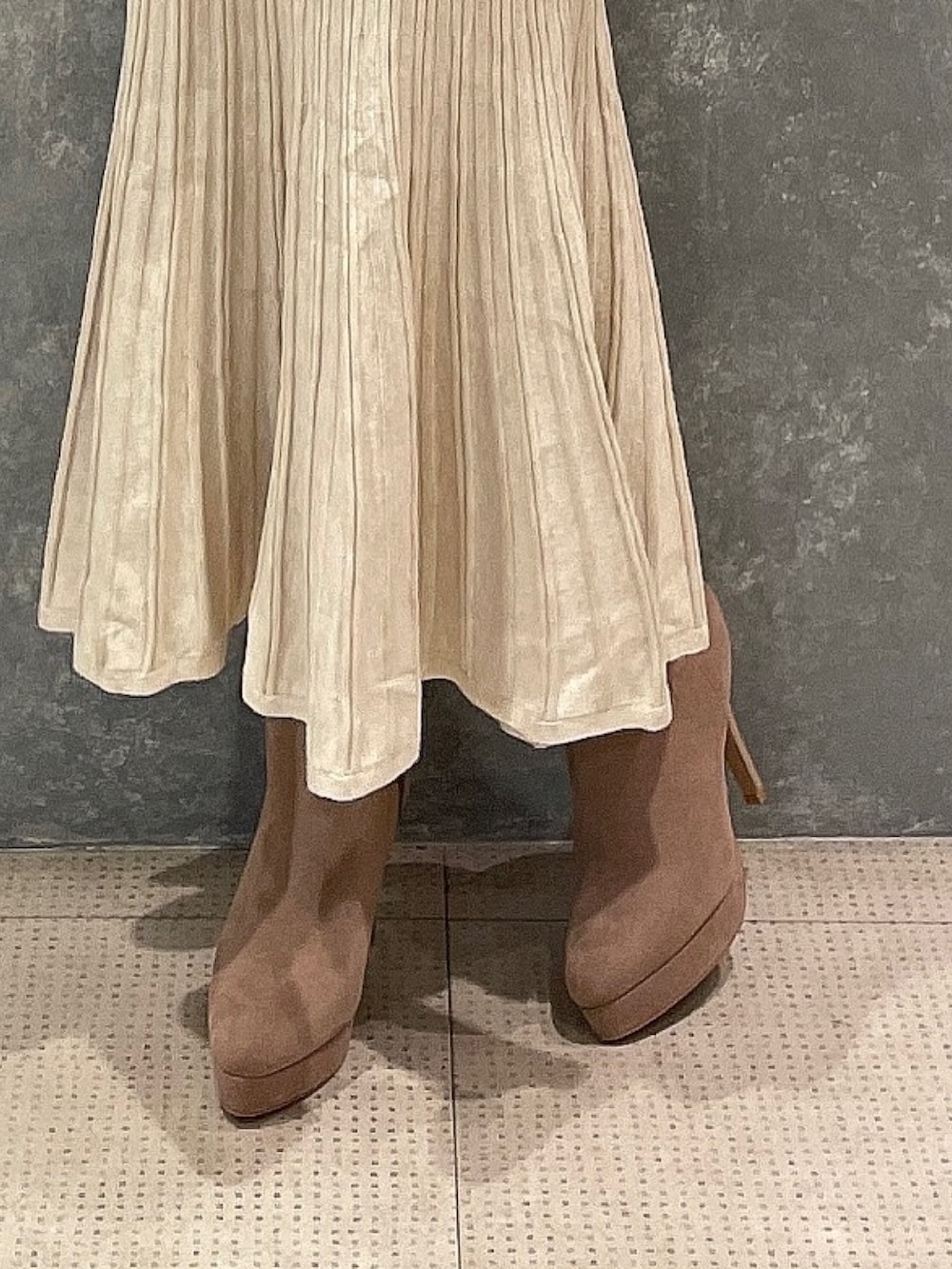 ベージュ系のブルゾン、ホワイト系のワンピース、ベージュ系のブーツを着用したレディースの秋コーディネートの10枚目の写真