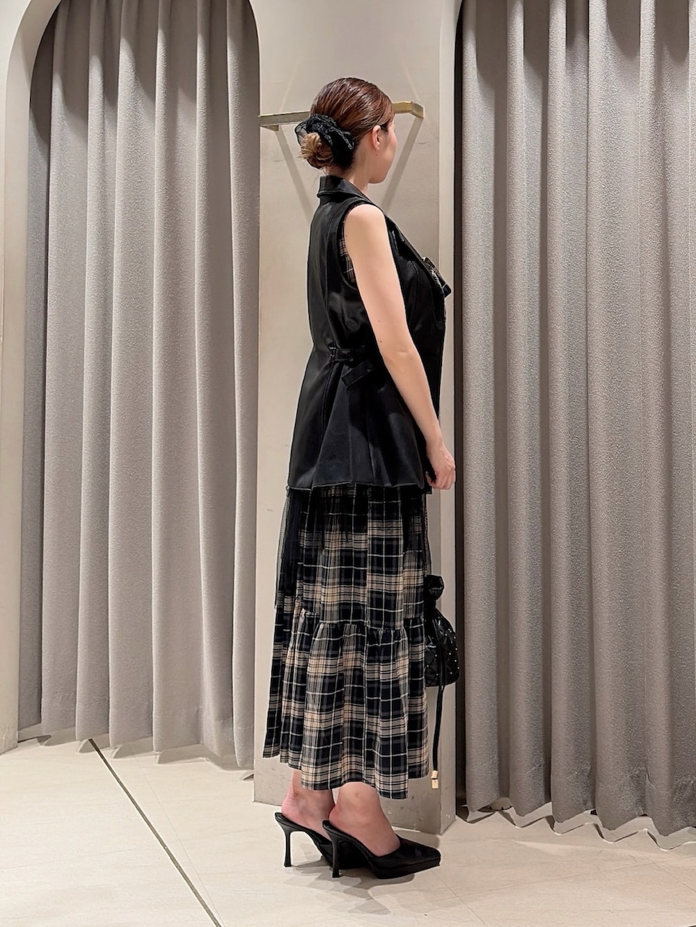 ブラック系のベスト、その他のワンピース、ブラック系のハンドバッグを着用したレディースの夏コーディネートの3枚目の写真