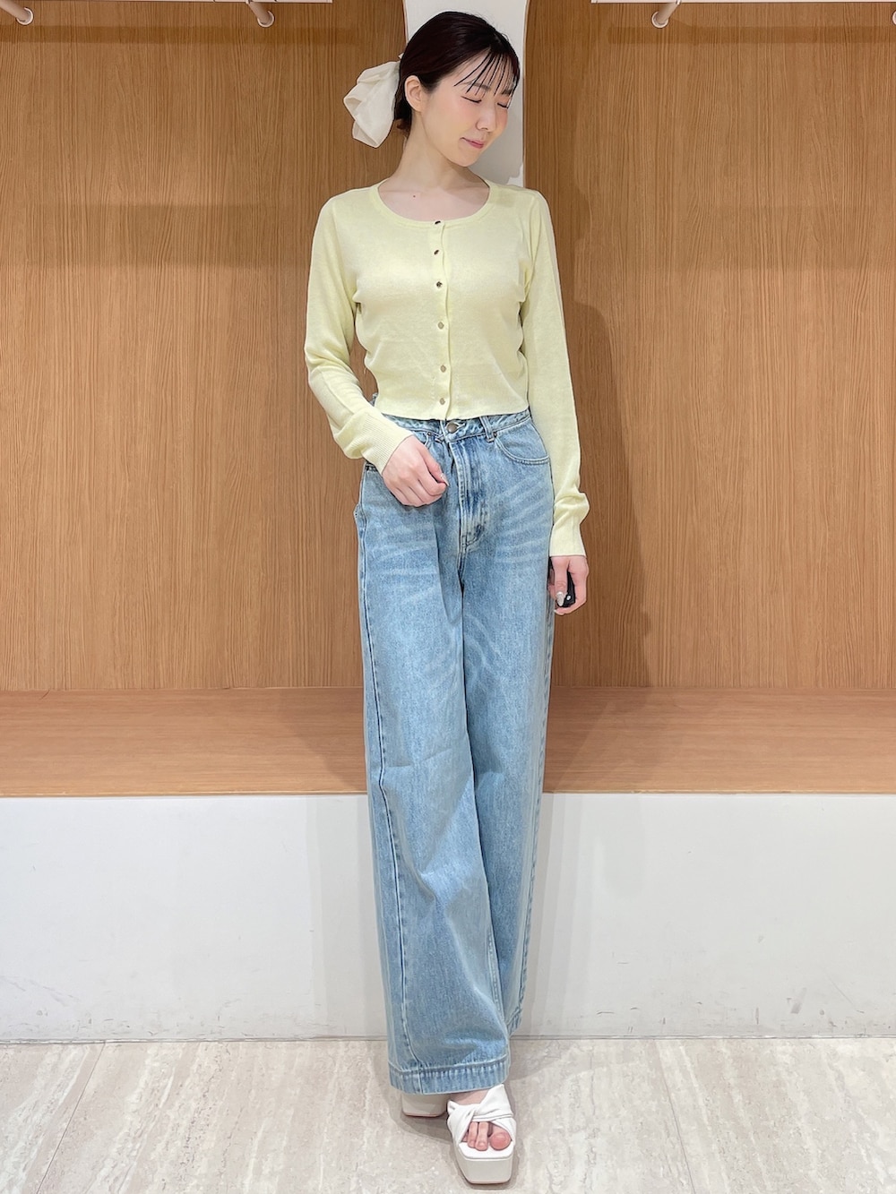 ホワイト系のテーラードジャケット、イエロー系のカーディガン/ボレロ、ブルー系のデニムパンツを着用したレディースの春コーディネートの2枚目の写真
