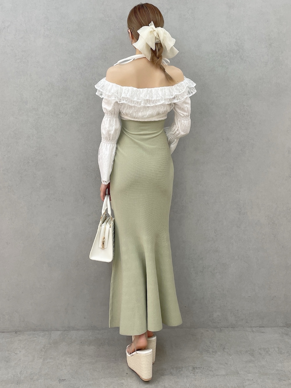 グリーン系のワンピース、ホワイト系のハンドバッグ、ホワイト系のサンダルを着用したレディースの春コーディネートの4枚目の写真