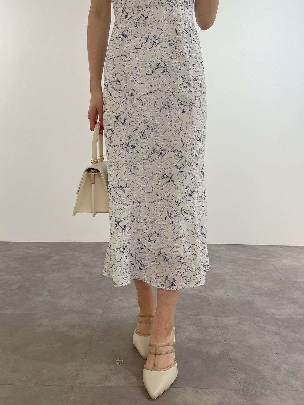 ホワイト系のワンピース、ホワイト系のハンドバッグ、ホワイト系のパンプスを着用したレディースの春コーディネートの8枚目の写真