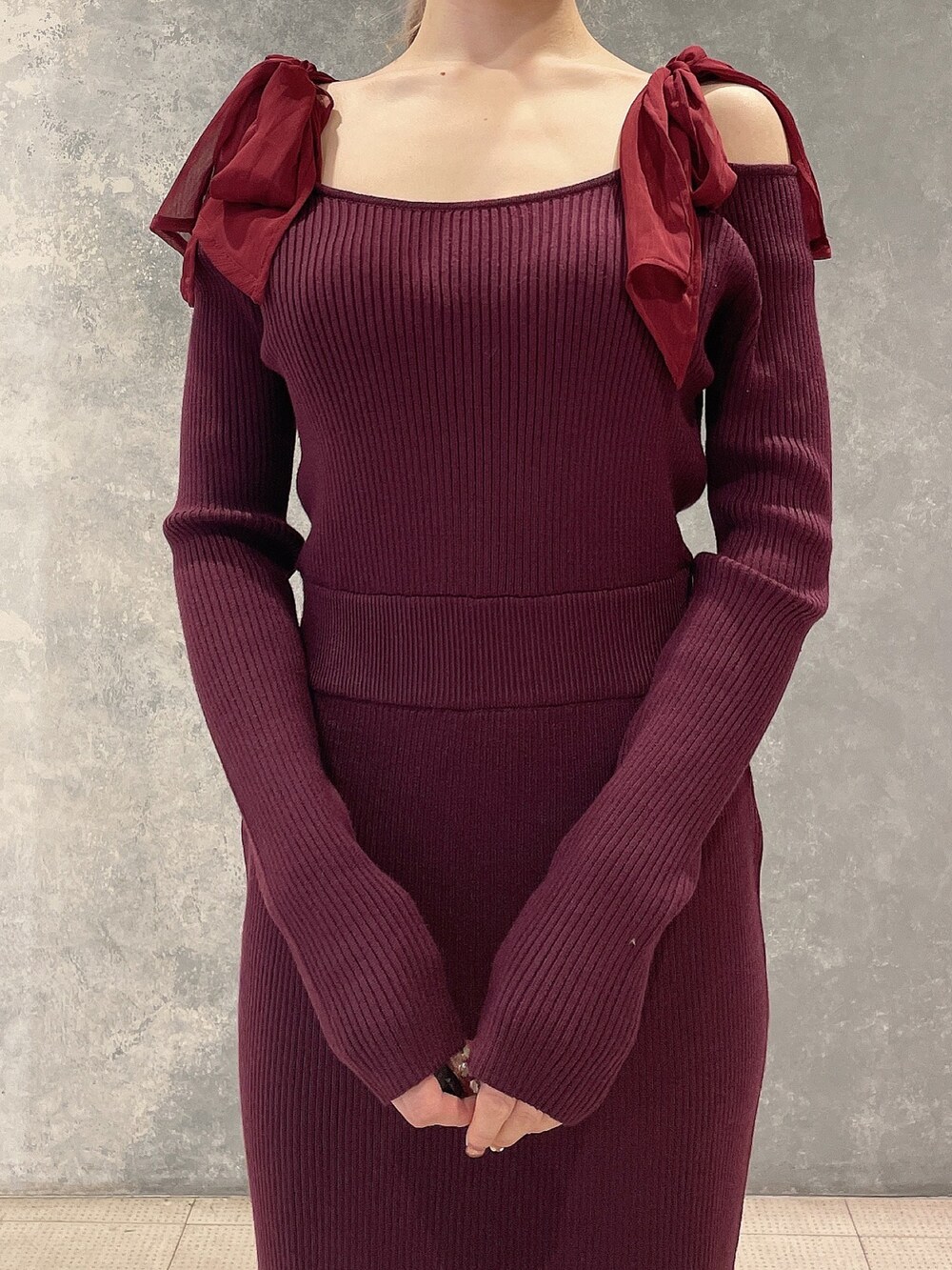 レッド系のワンピース、ブラック系のブーツを着用したレディースの秋コーディネートの5枚目の写真