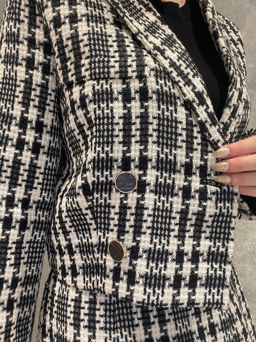 ブラック系のブーツ、ブラック系のスカート、ブラック系のテーラードジャケットを着用したレディースの夏コーディネートの6枚目の写真