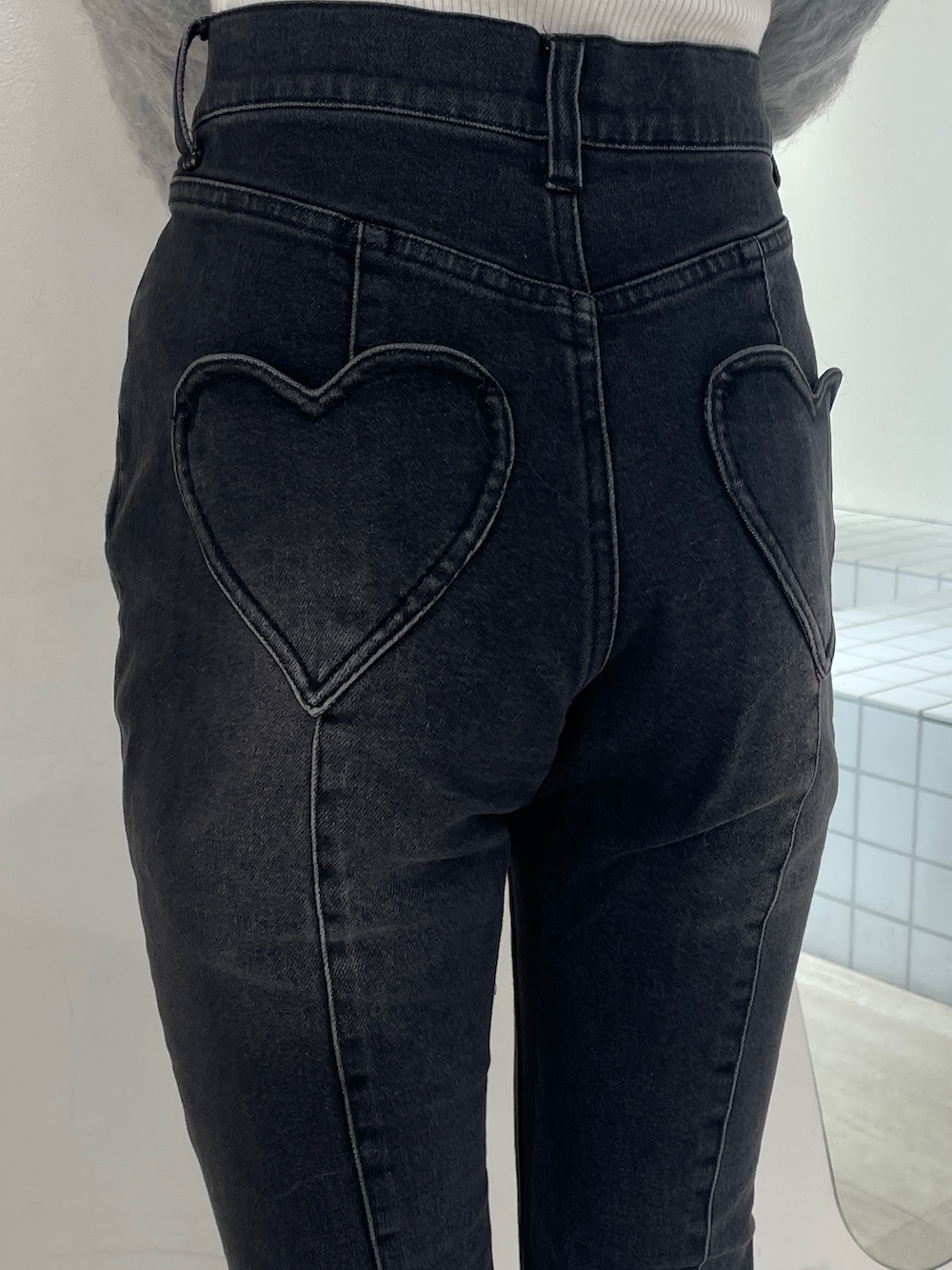 グレー系のニット/セーター、ブラック系のデニムパンツ、ブラック系のブーツを着用したレディースの冬コーディネートの5枚目の写真