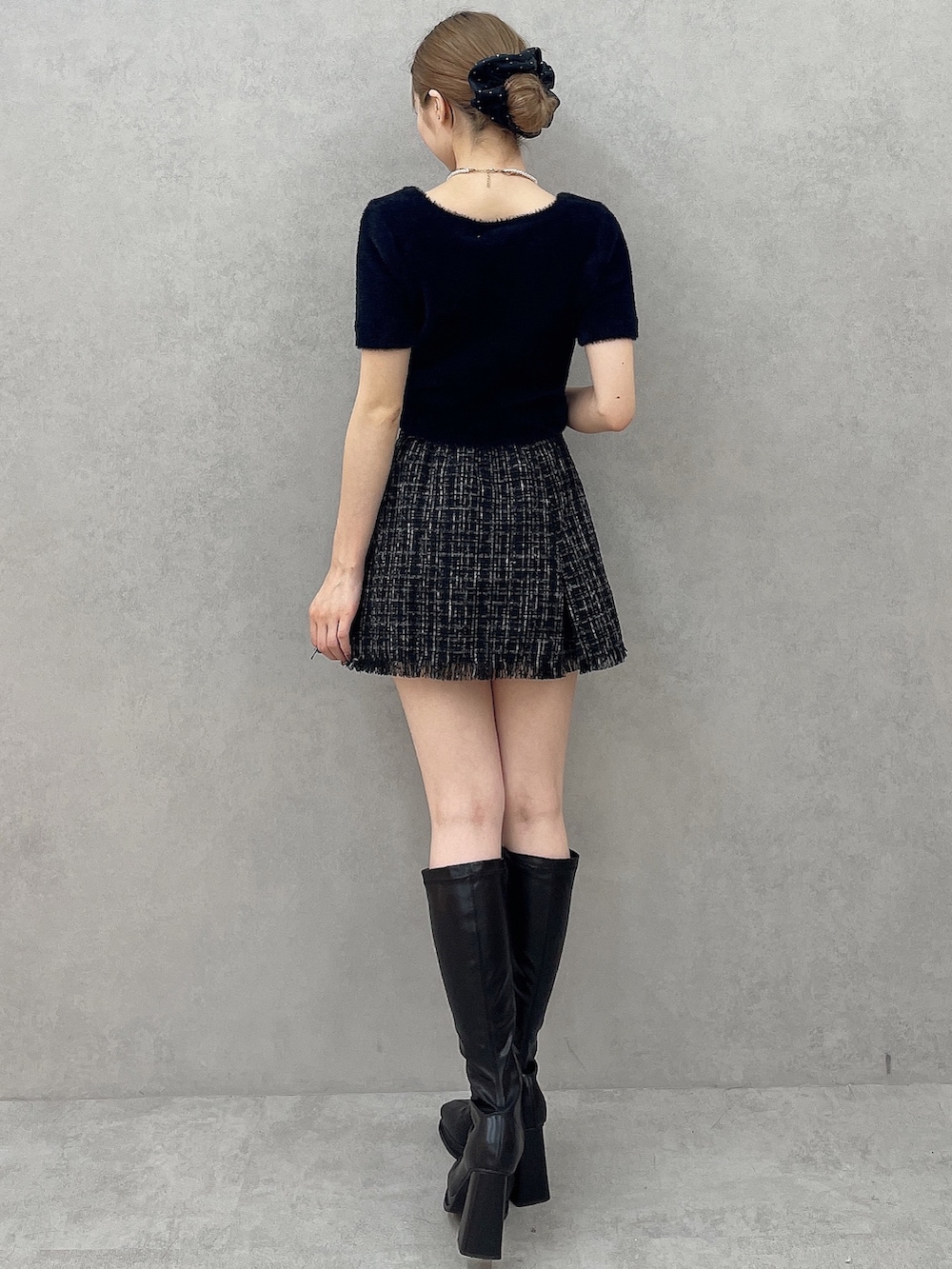 ブラック系のニット/セーター、ブラック系のスカート、ブラック系のシュシュを着用したレディースの夏コーディネートの3枚目の写真