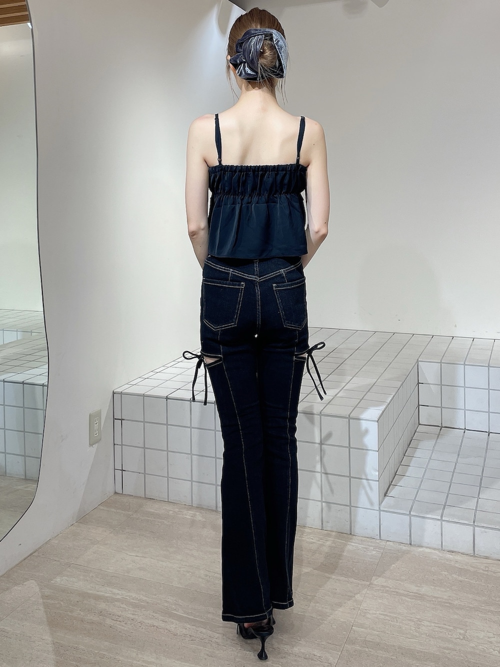 ブラック系のデニムパンツ、ブラック系のキャミソール、ブラック系のパンプスを着用したレディースの秋コーディネートの3枚目の写真