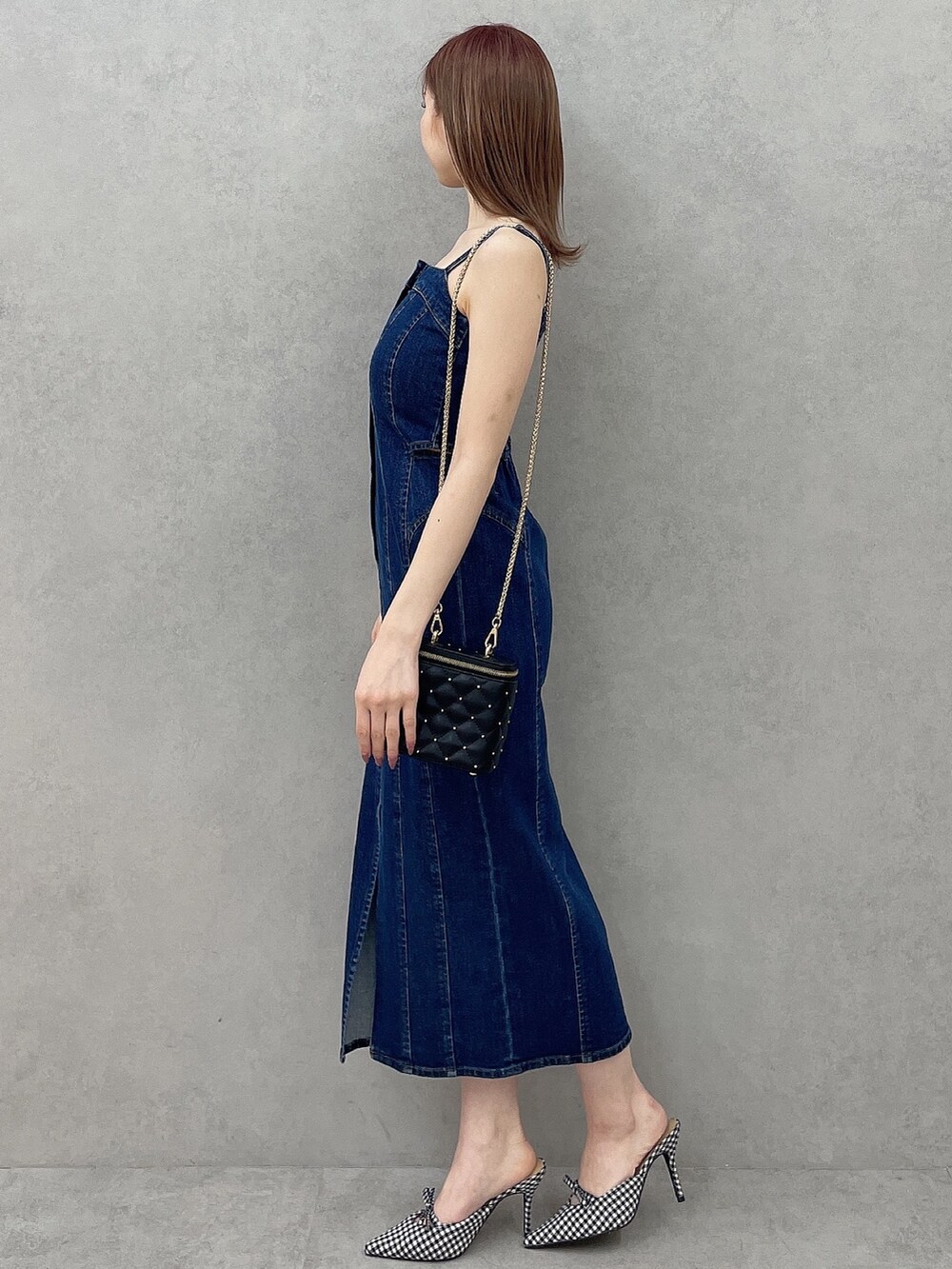 ブルー系のワンピース、ブラック系のショルダーバッグ、その他のパンプスを着用したレディースの冬コーディネートの3枚目の写真