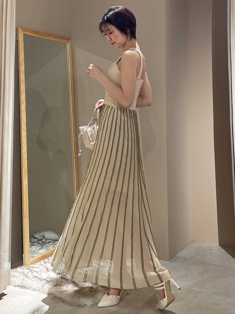 ホワイト系のワンピース、ブラック系のデニムジャケットを着用したレディースの春コーディネートの5枚目の写真