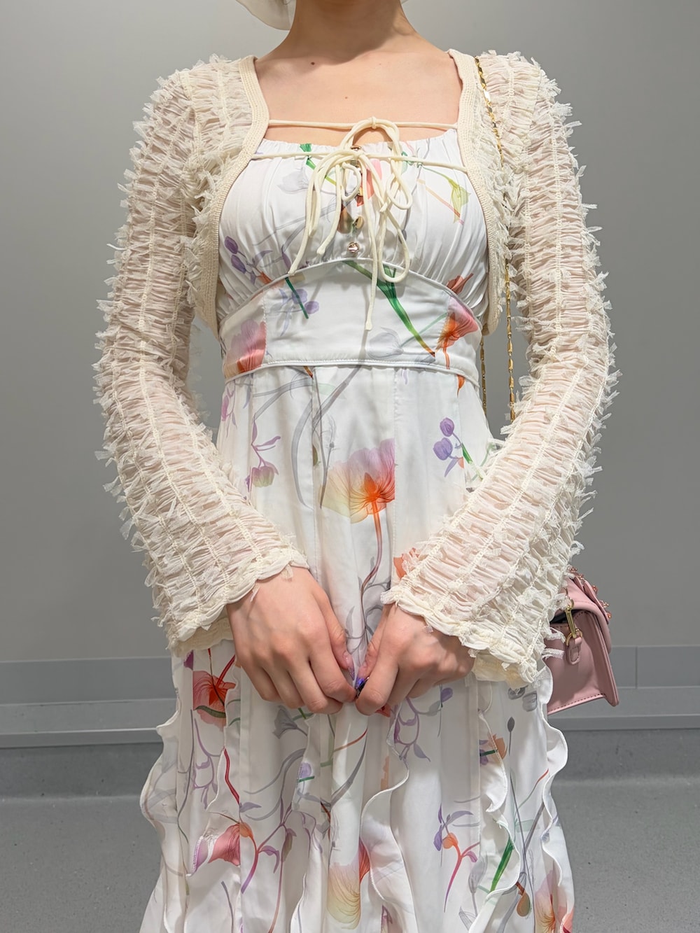 ホワイト系のワンピース、ピンク系のショルダーバッグ、ホワイト系のパンプスを着用したレディースの冬コーディネートの5枚目の写真