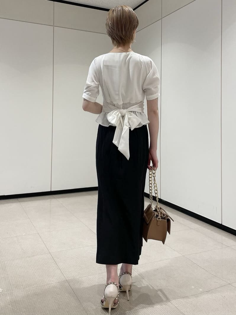 ホワイト系のパンプス、ブラウン系のショルダーバッグ、ホワイト系のシャツ/ブラウスを着用したレディースの夏コーディネートの3枚目の写真