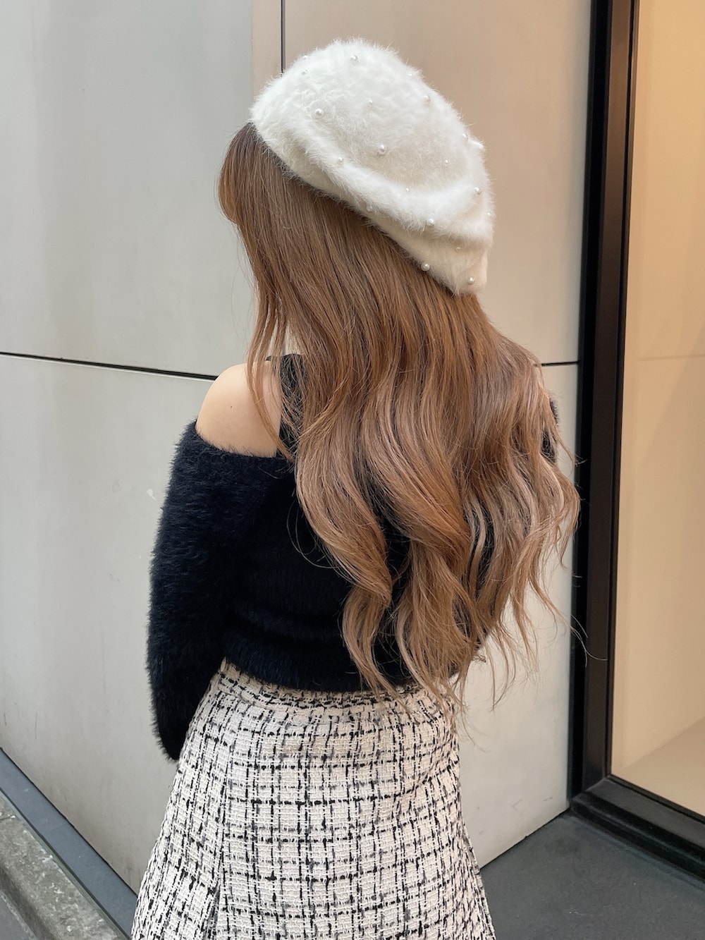 ブラック系のブーツ、ホワイト系のスカート、ブラック系のニット/セーターを着用したレディースの秋コーディネートの4枚目の写真