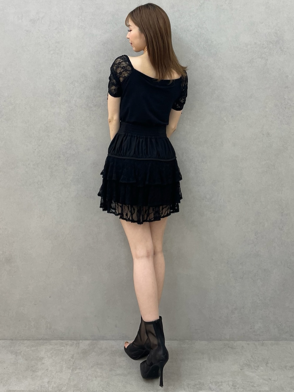 ブラック系のTシャツ/カットソー、ブラック系のスカート、ブラック系のブーツを着用したレディースの春コーディネートの3枚目の写真