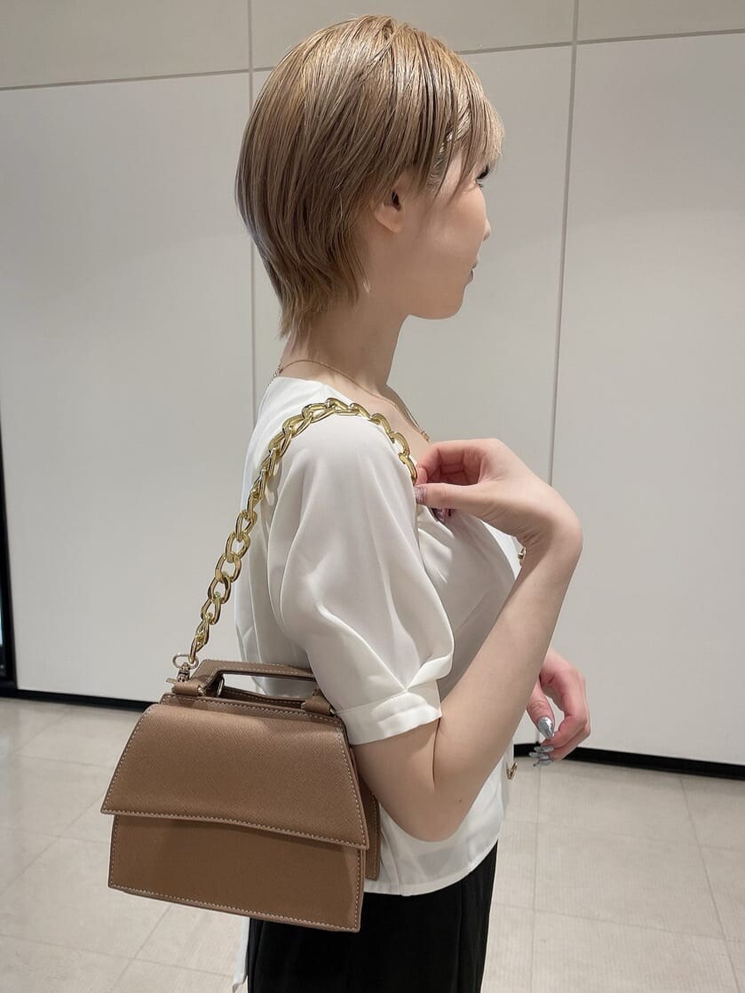 ホワイト系のパンプス、ブラウン系のショルダーバッグ、ホワイト系のシャツ/ブラウスを着用したレディースの夏コーディネートの6枚目の写真