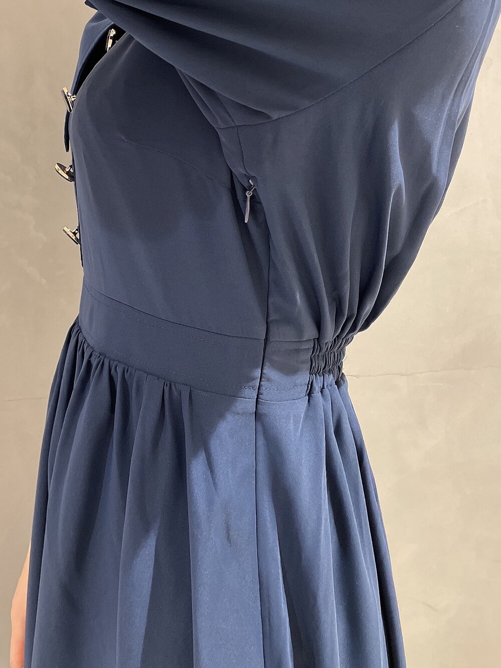 ブラック系のハンドバッグ、ブルー系のワンピース、ブラック系のパンプスを着用したレディースの冬コーディネートの7枚目の写真