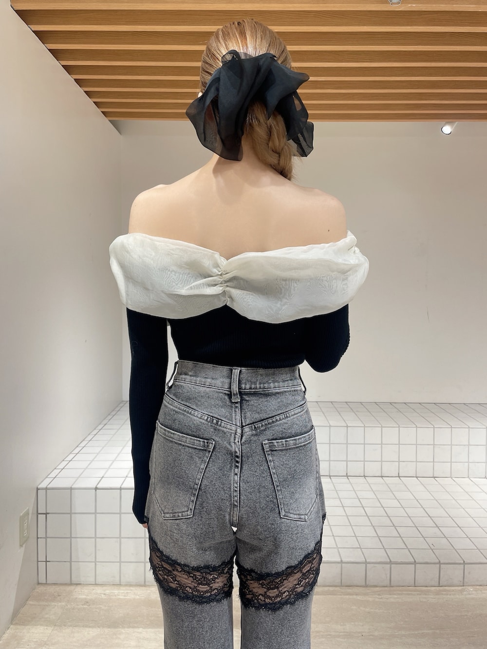 ブラック系のニット/セーター、グレー系のデニムパンツ、ブラック系のブーツを着用したレディースの春コーディネートの4枚目の写真