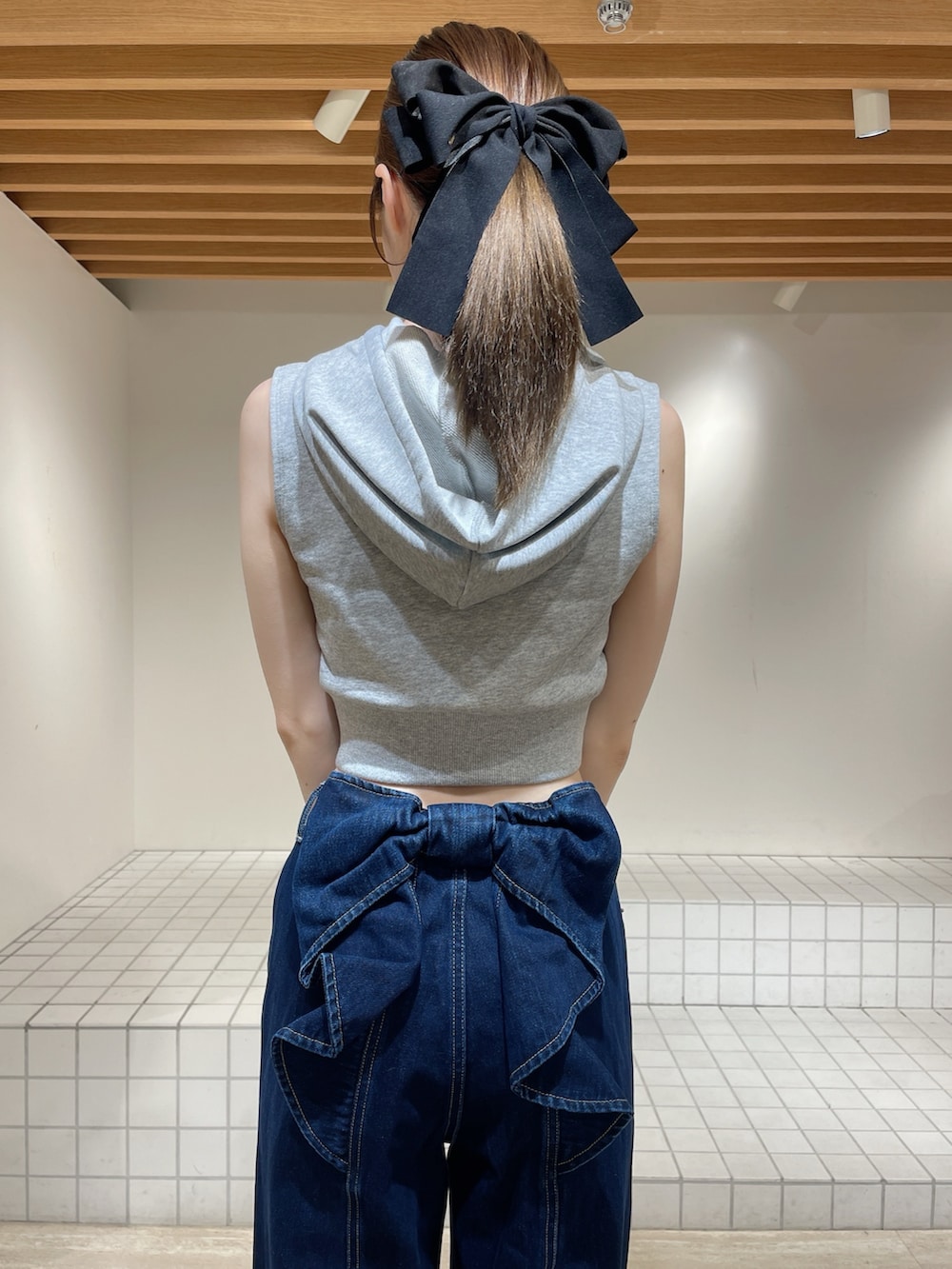 グレー系のパーカー、ブルー系のデニムパンツ、ブラック系のサンダルを着用したレディースの春コーディネートの5枚目の写真