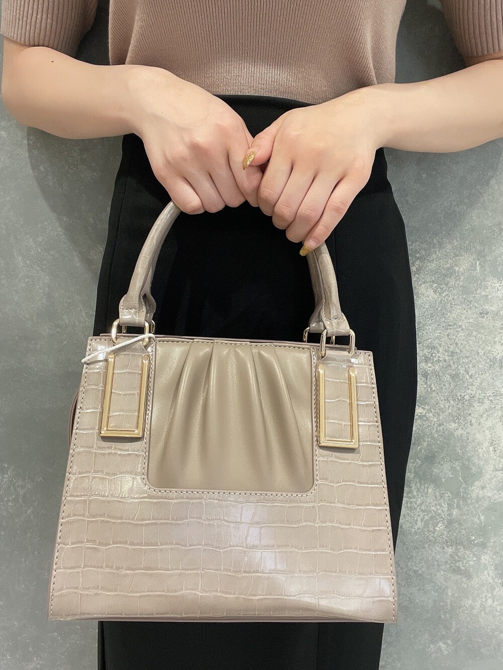 ブラック系のサンダル、ベージュ系のニット/セーター、ブラック系のスカートを着用したレディースの夏コーディネートの6枚目の写真