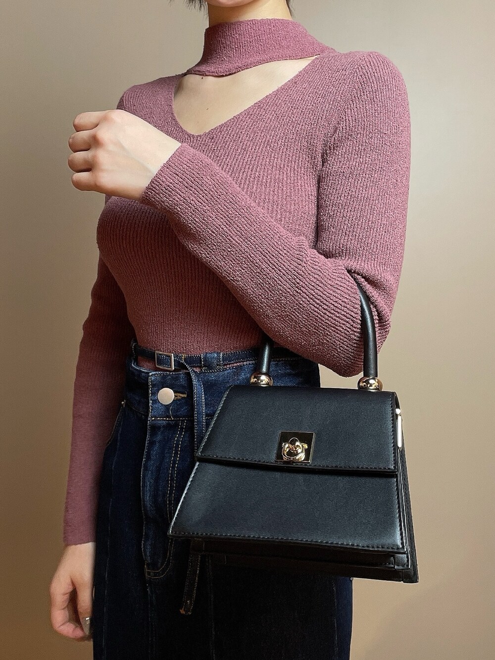 ピンク系のニット/セーター、ブルー系のデニムスカート、ブラック系のパンプスを着用したレディースの冬コーディネートの6枚目の写真